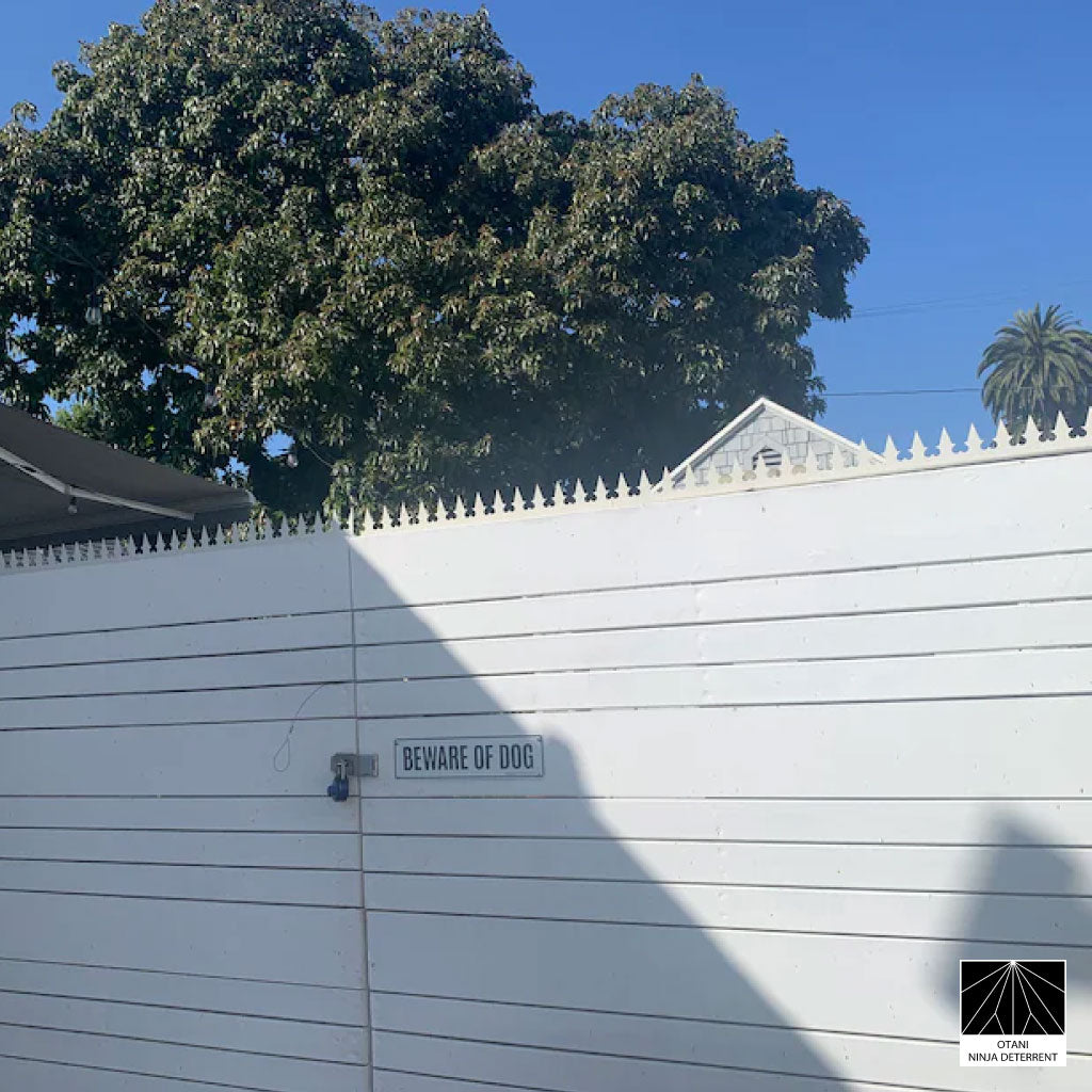 GIZAGIZA White heart spike installed on modern white gate with warning sign – clean design and security in harmony