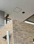 Sleek silver Ninja Deterrent™ installed on modern brick wall—discreet bird and intruder deterrent