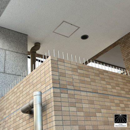 Sleek silver Ninja Deterrent™ installed on modern brick wall—discreet bird and intruder deterrent
